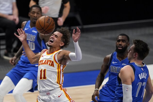 Atlanta Hawks' Trae Young (11) is fouled going to the basket between Dallas Mavericks' Dorian Finney-Smith,Tim Hardaway Jr., center, and Luka Doncic (77) during an NBA basketball game in Dallas, Wednesday, Feb. 10, 2021. (AP Photo/Tony Gutierrez)