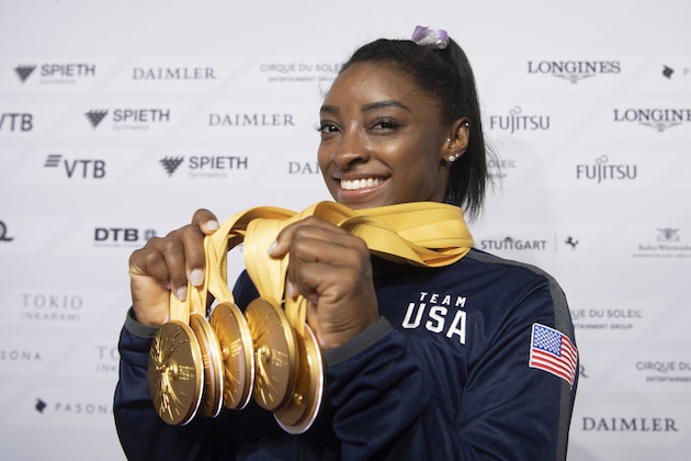 File-This Oct. 13, 2019 file photo shows Simone Biles of the United States with her five gold medals she won at the Gymnastics World Championships in Stuttgart, Germany.  Biles is golden, deft, elastic â€“ Ruler of all things gymnastic. (Marijan Murat/dpa via AP, File)