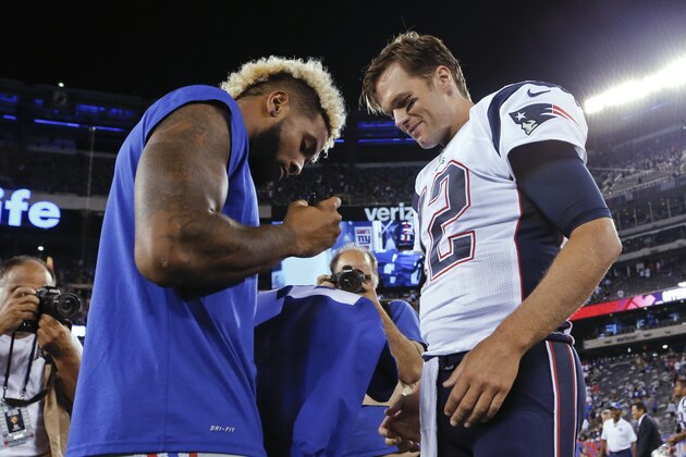 New York Giants wide receiver Odell Beckham, left, signs a jersey as New England Patriots quarterback Tom Brady, right, watches after a preseason NFL football game Thursday, Sept. 1, 2016, in East Rutherford, N.J. The Giants won 17-9. (AP Photo/Kathy Willens)