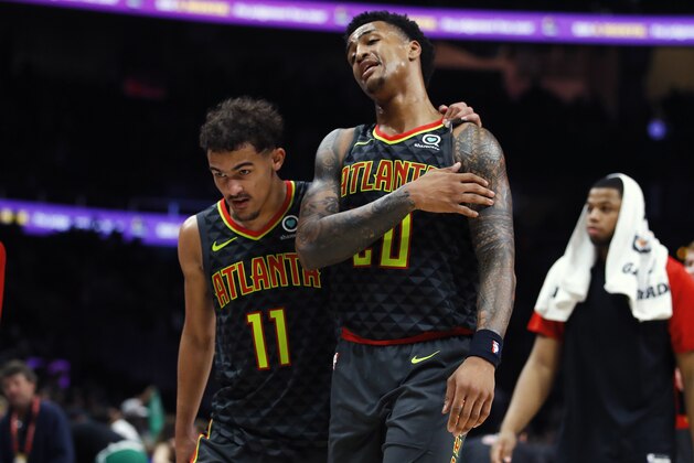 FILE - In this Jan. 19, 2019, file photo, Atlanta Hawks guard Trae Young (11) and forward John Collins (20) leave the court after the team's 113-105 loss to the Boston Celtics in an NBA basketball game, in Atlanta. The instant camaraderie these two talented youngsters have make the Hawks one of the most intriguing storylines in the NBA losers bracket. (AP Photo/Todd Kirkland, File)