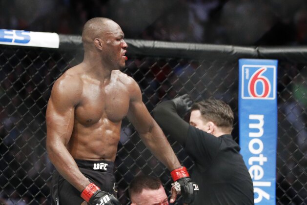 Kamaru Usman stands up after defeating Colby Covington in a mixed martial arts welterweight championship bout at UFC 245, Saturday, Dec. 14, 2019, in Las Vegas. (AP Photo/John Locher)