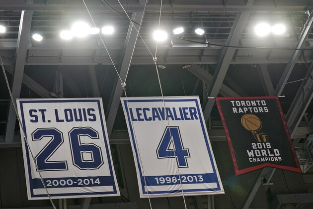 The Toronto Raptors 2019 World Championship banner hangs along with former Tampa Bay Lightning players Martin St. Louis and Vincent Lecavalier in the rafters at Amalie Arena before an NBA preseason basketball game between the Raptors and the Miami Heat Friday, Dec. 18, 2020, in Tampa, Fla. The Raptors are playing their home games in Tampa as a result of Canada's strict travel regulations stemming from the coronavirus pandemic. (AP Photo/Chris O'Meara)