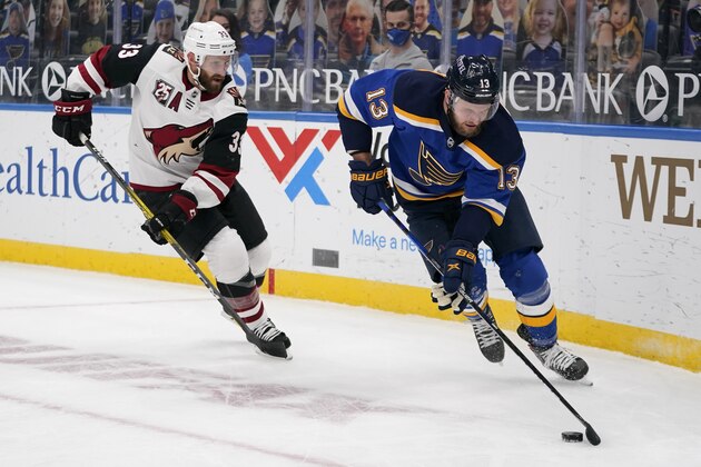 St. Louis Blues' Kyle Clifford (13) handles the puck as Arizona Coyotes' Alex Goligoski (33) defends during the second period of an NHL hockey game Monday, Feb. 8, 2021, in St. Louis. (AP Photo/Jeff Roberson)