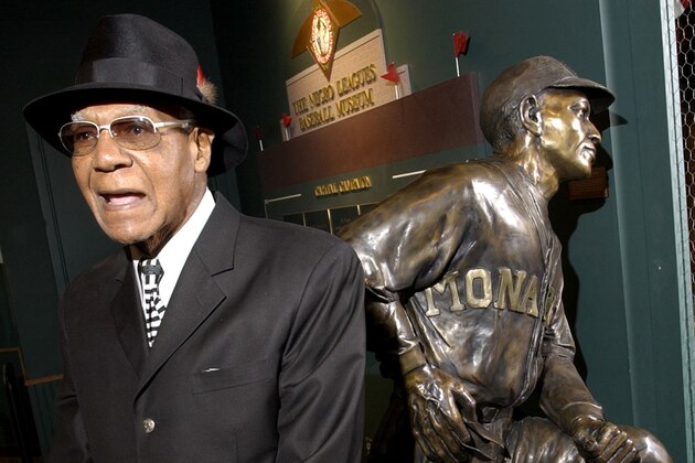 FILE - In this file photo taken Feb. 11, 2005, Buck O'Neil talks about playing in the Negro League in front of a statue of himself at the Negro League Baseball Museum in Kansas City, Mo. Major League Baseball plays its annual All-Star game Tuesday, July 10, 2012, the museum will likely have experienced a significant windfall, financially and in terms of awareness, possibly ensuring its future for years to come. O'Neil, the late Kansas City Monarchs star and one of the museum's founders, traveled the world telling stories of the game's great black players. (AP Photo/Charlie Riedel, file)