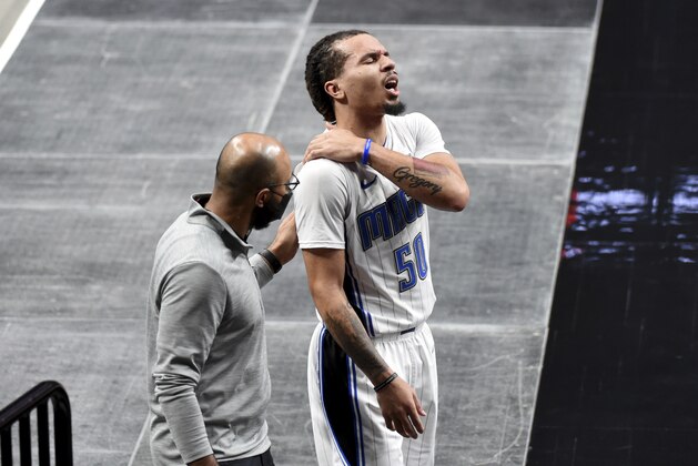 Orlando Magic guard Cole Anthony is escorted off the court during the first half of an NBA basketball game against the Portland Trail Blazers in Portland, Ore., Tuesday, Feb. 9, 2021. (AP Photo/Steve Dykes)
