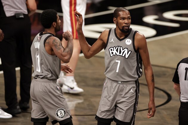 Brooklyn Nets forward Kevin Durant (7) high-fives guard Kyrie Irving during an NBA basketball game Monday, Jan. 25, 2021, in New York. The Nets won 98-85. (AP Photo/Adam Hunger)