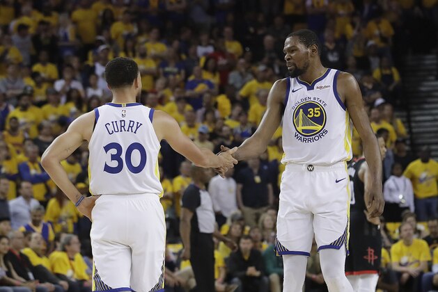 Golden State Warriors guard Stephen Curry (30) reacts with forward Kevin Durant (35) during the first half of Game 1 of a second-round NBA basketball playoff series against the Houston Rockets in Oakland, Calif., Sunday, April 28, 2019. (AP Photo/Jeff Chiu)