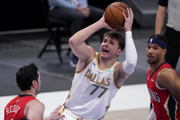 New Orleans Pelicans' JJ Redick, left, and Josh Hart defend against Dallas Mavericks' Luka Doncic (77) during the first half of an NBA basketball game in Dallas, Friday, Feb. 12, 2021. (AP Photo/Tony Gutierrez)