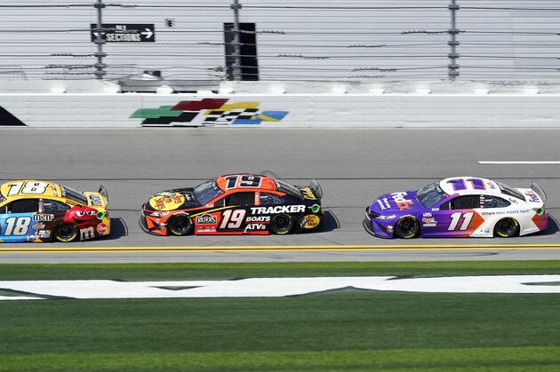 Kyle Busch (18) races ahead of Martin Truex Jr. (19) and Denny Hamlin (11) during a NASCAR Daytona 500 auto race practice session at Daytona International Speedway, Wednesday, Feb. 10, 2021, in Daytona Beach, Fla. (AP Photo/John Raoux)