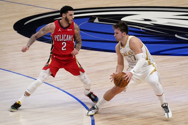 New Orleans Pelicans' Lonzo Ball (2) defends as Dallas Mavericks' Luka Doncic (77) handles the ball in the first half of an NBA basketball game in Dallas, Friday, Feb. 12, 2021. (AP Photo/Tony Gutierrez)