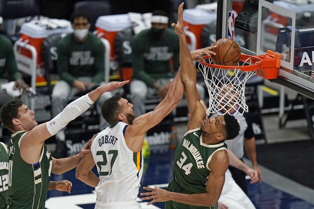 Utah Jazz center Rudy Gobert (27) dunks between Milwaukee Bucks' Brook Lopez (11) and Giannis Antetokounmpo (34) during the first half of an NBA basketball game Friday, Feb. 12, 2021, in Salt Lake City. (AP Photo/Rick Bowmer)
