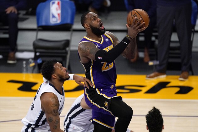 Los Angeles Lakers forward LeBron James, right, goes to the basket as Memphis Grizzlies center Xavier Tillman defends during the first half of an NBA basketball game Friday, Feb. 12, 2021, in Los Angeles. (AP Photo/Mark J. Terrill)