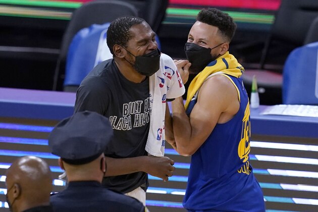 Brooklyn Nets forward Kevin Durant, left, laughs with Golden State Warriors guard Stephen Curry after the Nets defeated the Warriors in an NBA basketball game in San Francisco, Saturday, Feb. 13, 2021. (AP Photo/Jeff Chiu)