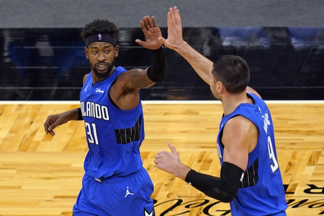 Orlando Magic guard Terrence Ross (31) gets a high-five from center Nikola Vucevic, right, after sinking a 3-point shot against the Charlotte Hornets during the second half of an NBA basketball game, Sunday, Jan. 24, 2021, in Orlando, Fla. (AP Photo/John Raoux)