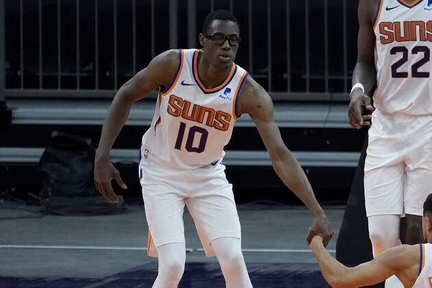 Phoenix Suns forward Jalen Smith (10), center Deandre Ayton (22) and forward Mikal Bridges (25) helps  guard Devin Booker (1) up during the second half of a preseason NBA basketball game against the Los Angeles Lakers, Friday, Dec. 18, 2020, in Phoenix, Ariz. (AP Photo/Matt York)