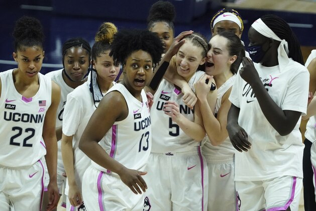 Connecticut guard Nika Muhl (10) hugs guard Paige Bueckers (5) after defeating South Carolina in overtime of an NCAA college basketball game in Storrs, Conn., Monday, Feb. 8, 2021. (David Butler/Pool Photo via AP)