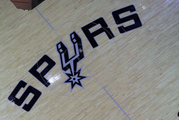 Cecilio Santibanez places an NBA Finals logo on the court prior to Game 1 of the NBA Finals basketball series between the San Antonio Spurs and Miami Heat, Thursday, June 5, 2014, in San Antonio. (AP Photo/Eric Gay)
