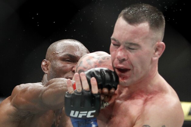 Kamaru Usman, left, hits Colby Covington in a mixed martial arts welterweight championship bout at UFC 245, Saturday, Dec. 14, 2019, in Las Vegas. (AP Photo/John Locher)