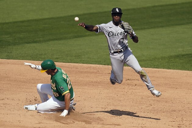 Chicago White Sox shortstop Tim Anderson (7) throws to first base after forcing out Oakland Athletics' Matt Olson, left, at second base on a double play hit into by Stephen Piscotty during the sixth inning of Game 2 of an American League wild-card baseball series Wednesday, Sept. 30, 2020, in Oakland, Calif. (AP Photo/Eric Risberg)