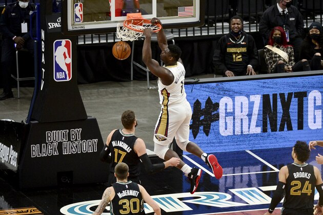 New Orleans Pelicans forward Zion Williamson (1) dunks next to Memphis Grizzlies center Jonas Valanciunas (17) during the first half of an NBA basketball game Tuesday, Feb. 16, 2021, in Memphis, Tenn. (AP Photo/Brandon Dill)