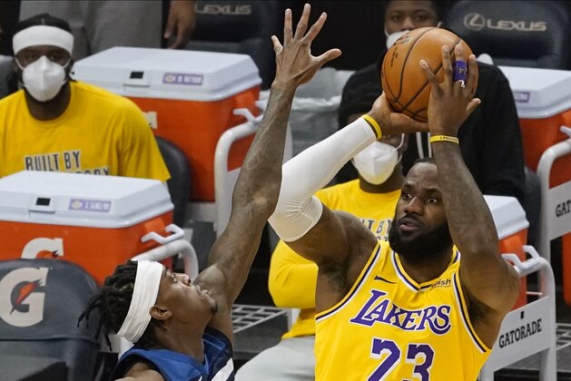 Los Angeles Lakers' LeBron James (23) shoots as Minnesota Timberwolves' Jarred Vanderbilt (8) defends in the first half of an NBA basketball game, Tuesday, Feb. 16, 2021, in Minneapolis. (AP Photo/Jim Mone)