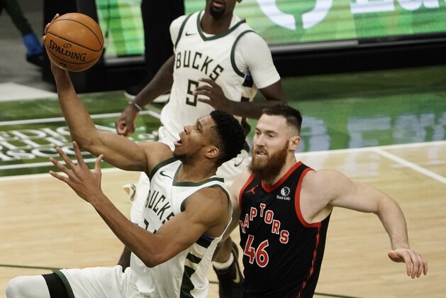 Milwaukee Bucks' Giannis Antetokounmpo shoots past Toronto Raptors' Aron Baynes during the second half of an NBA basketball game Tuesday, Feb. 16, 2021, in Milwaukee. (AP Photo/Morry Gash)