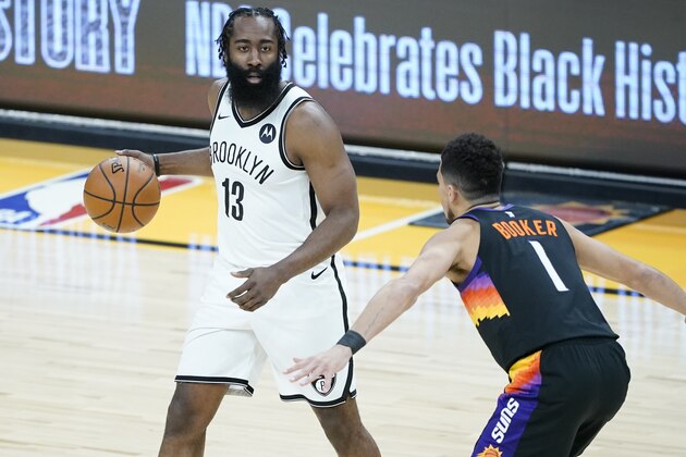 Brooklyn Nets guard James Harden (13) looks to pass as Phoenix Suns guard Devin Booker (1) defends during the first half of an NBA basketball game, Tuesday, Feb. 16, 2021, in Phoenix.(AP Photo/Matt York)