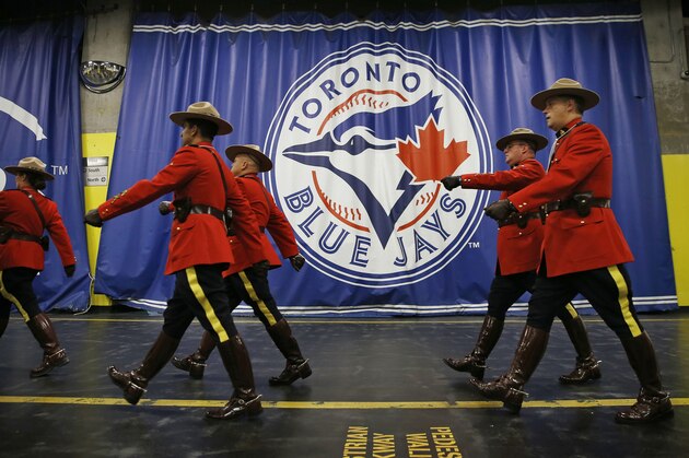 Members of the Royal Canadian Mounted Police march past the Toronto Blue Jays logo before Game 4 of baseball's American League Championship Series against the Kansas City Royals on Tuesday, Oct. 20, 2015, in Toronto. (AP Photo/Matt Slocum)
