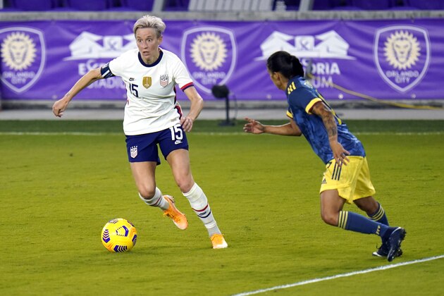 United States forward Megan Rapinoe (15) moves the ball past Colombia defender Carolina Arias, right, during the second half of an international friendly soccer match, Friday, Jan. 22, 2021, in Orlando, Fla. (AP Photo/John Raoux)