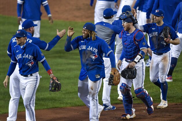 Toronto Blue Jays' Cavan Biggio, left, Vladimir Guerrero Jr., second from left, Danny Jansen, second from right and Randal Grichuk, right, celebrate with teammates after a 4-1 win over the New York Yankees in a baseball game in Buffalo, N.Y., Thursday, Sept. 24, 2020. Toronto clinched a postseason berth with the win. (AP Photo/Adrian Kraus)