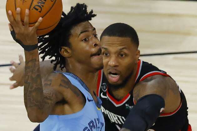 Memphis Grizzlies' Ja Morant (12) drives past Portland Trail Blazers' Damian Lillard, right, during the second half of an NBA basketball game Saturday, Aug. 15, 2020, in Lake Buena Vista, Fla. (Kevin C. Cox/Pool Photo via AP)