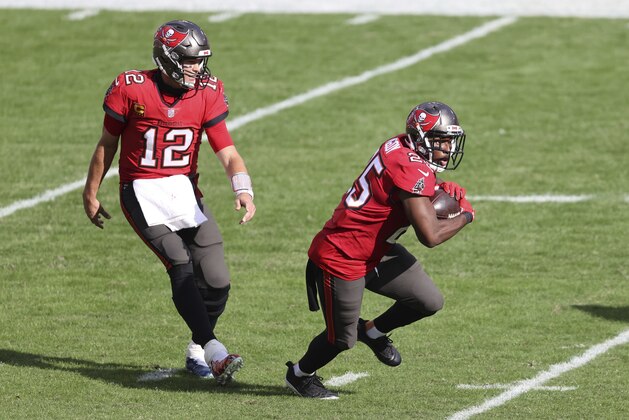 Tampa Bay Buccaneers quarterback Tom Brady (12) hands off to running back LeSean McCoy (25) during the second half of an NFL football game against the Minnesota Vikings Sunday, Dec. 13, 2020, in Tampa, Fla. (AP Photo/Mark LoMoglio)