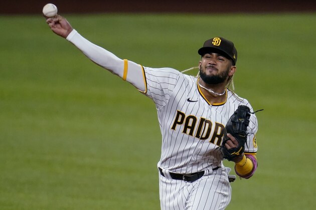 FILE - In this Oct. 8, 2020, file photo, San Diego Padres' Fernando Tatis Jr. throws to first for the out on Los Angeles Dodgers' Mookie Betts during the first inning in Game 3 of a baseball National League Division Series in Arlington, Texas. Tatis has agreed to a 14-year deal that will keep the shortstop with the Padres until he's 35 years old, according to two people familiar with the situation. (AP Photo/Sue Ogrocki, File)
