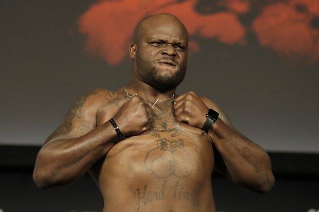 Derrick Lewis reacts while posing atop a scale prior to his heavyweight mixed martial arts bout against Daniel Cormier during the weigh-ins ahead of UFC 230, Friday, Nov. 2, 2018, at Madison Square Garden in New York. (AP Photo/Julio Cortez)