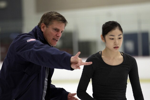 Olympic figure skating champion Kim Yu-na, right, of South Korea, and her new coach Peter Oppegard chat while skating in Artesia, Calif., Tuesday, Oct. 5, 2010. (AP Photo/Jae C. Hong)