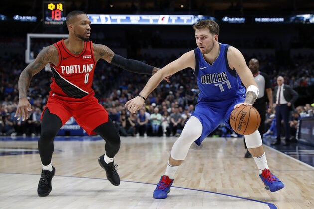 Portland Trail Blazers' Damian Lillard (0) defends against Dallas Mavericks' Luka Doncic (77) during an NBA basketball game in Dallas, Sunday, Oct. 27, 2019. (AP Photo/Tony Gutierrez)