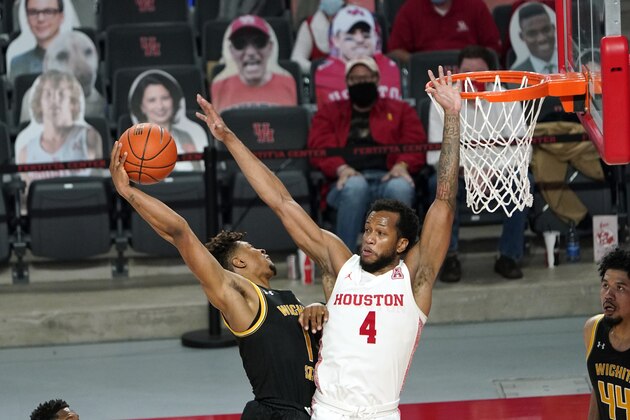 Wichita State's Tyson Etienne (1) goes up for a shot as Houston's Justin Gorham (4) defends during the second half of an NCAA college basketball game Wednesday, Jan. 6, 2021, in Houston. (AP Photo/David J. Phillip)