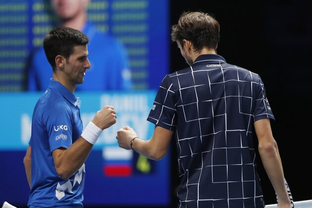 Daniil Medvedev of Russia, right, cheers with Novak Djokovic of Serbia after winning a tennis match at the ATP World Finals tennis tournament at the O2 arena in London, Wednesday, Nov. 18, 2020. (AP Photo/Frank Augstein)