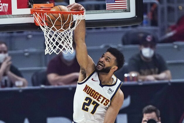 Denver Nuggets' Jamal Murray (27) dunks next to Cleveland Cavaliers' Collin Sexton (2) during the first half of an NBA basketball game Friday, Feb. 19, 2021, in Cleveland. (AP Photo/Tony Dejak)