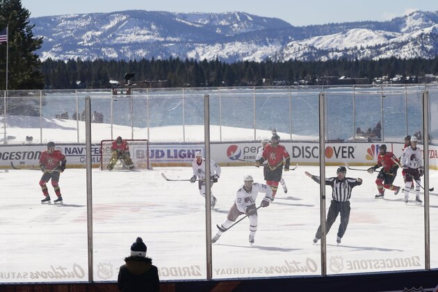 CORRECTS STATE TO NEVADA-Members of the Colorado Avalanche, in white, and the Vegas Golden Knights, red play during the first period of the Outdoor Lake Tahoe NHL hockey game in Stateline, Nev., Saturday, Feb. 20, 2021. (AP Photo/Rich Pedroncelli))