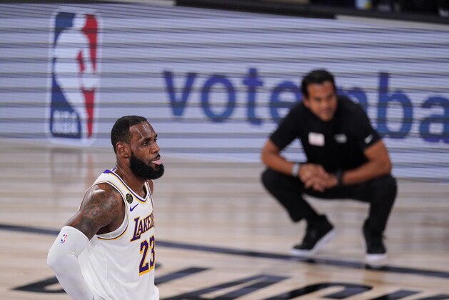 Los Angeles Lakers' LeBron James (23) looks on with Miami Heat's head coach Erik Spoelstra in the back ground during the first half in Game 3 of basketball's NBA Finals, Sunday, Oct. 4, 2020, in Lake Buena Vista, Fla. (AP Photo/Mark J. Terrill)