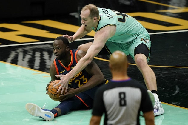 Golden State Warriors forward Draymond Green (23) and Charlotte Hornets center Cody Zeller battle for a loose ball during the second half of an NBA basketball game on Saturday, Feb. 20, 2021, in Charlotte, N.C. (AP Photo/Chris Carlson)