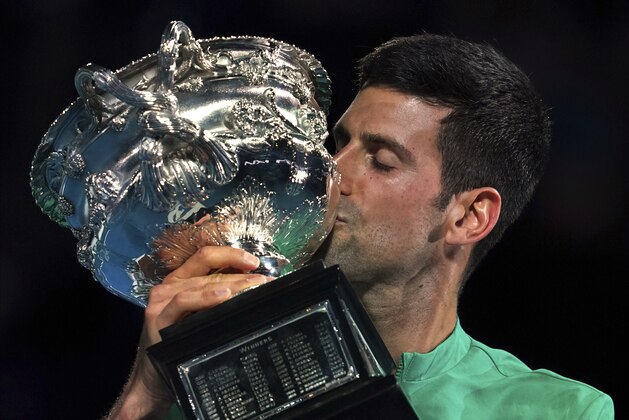 Serbia's Novak Djokovic kisses the Norman Brookes Challenge Cup after defeating Russia's Daniil Medvedev in the men's singles final at the Australian Open tennis championship in Melbourne, Australia, Sunday, Feb. 21, 2021.(AP Photo/Mark Dadswell)