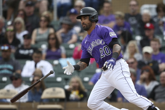 Colorado Rockies' Ian Desmond tosses his bat away as he heads to first base during the fourth inning of a spring training baseball game against the Cincinnati Reds Tuesday, March 10, 2020, in Scottsdale, Ariz. (AP Photo/Ross D. Franklin)