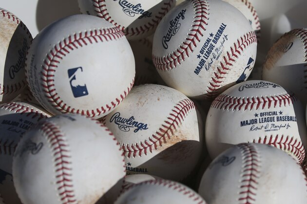 FILE - In this Feb. 14, 2020, file photo, baseballs sit in a bucket after they were used for fielding practice during spring training baseball workouts for pitchers and catchers at Cleveland Indians camp in Avondale, Ariz. Major League Baseball revamped its spring training exhibition schedule because of the pandemic, cutting travel for Florida-based teams in an effort to avoid the novel coronavirus, the league announced Friday, Feb. 12, 2021. (AP Photo/Ross D. Franklin, File)