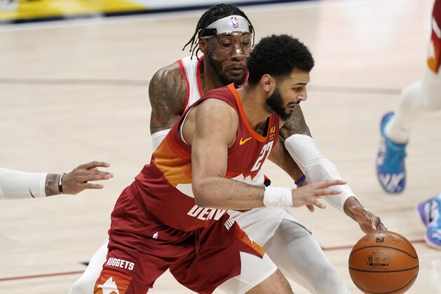 Denver Nuggets guard Jamal Murray, front, loses control of the ball as Portland Trail Blazers forward Robert Covington defends in the first half of an NBA basketball game on Tuesday, Feb. 23, 2021, in Denver. (AP Photo/David Zalubowski)