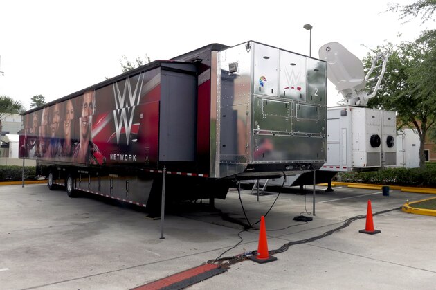 A trailer and a satellite truck to transmit wrestling broadcasts are parked outside the WWE Performance Center Tuesday, April 14, 2020, in Orlando, Fla.   Florida’s top emergency official last week amended Gov. Ron DeSantis’ stay-at-home order to include employees at the professional sports and media production with a national audience, if the location is closed to the public.  (AP Photo/John Raoux)