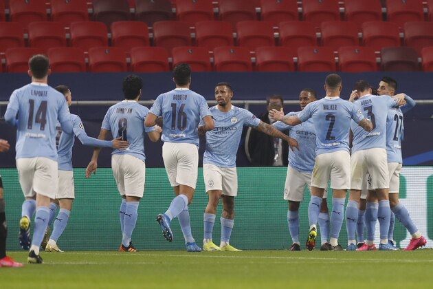 Manchester City players celebrate after Bernardo Silva scored his side's opening goal during the Champions League round of 16 first leg soccer match between Borussia Monchengladbach and Manchester City at the Puskas Arena stadium in Budapest, Hungary, Wednesday, Feb. 24, 2021. (AP Photo/Laszlo Balogh)