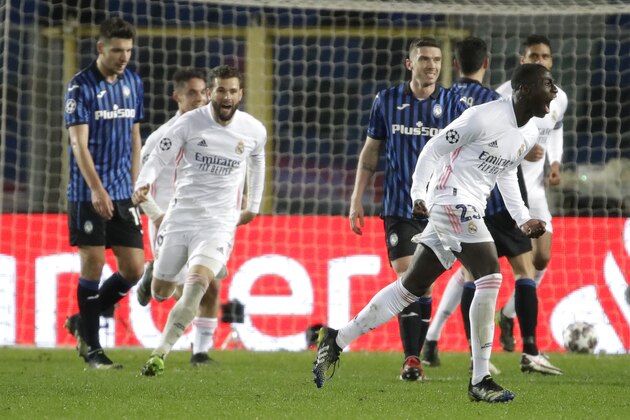 Real Madrid's Ferland Mendy, right, celebrates after scoring his side's opening goal during the Champions League, round of 16, first leg soccer match between Atlanta and Real Madrid, at the Gewiss Stadium in Bergamo, Wednesday, Feb. 24, 2021. (AP Photo/Luca Bruno)