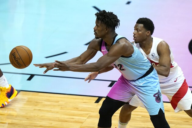 Miami Heat forward Jimmy Butler (22) passes as Toronto Raptors guard Kyle Lowry defend during the second half of an NBA basketball game, Wednesday, Feb. 24, 2021, in Miami. (AP Photo/Lynne Sladky)